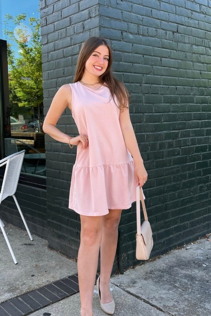 Playful and youthful spring brunch outfit: a light pink sleeveless drop-waist mini dress with beige pointed-toe heels.