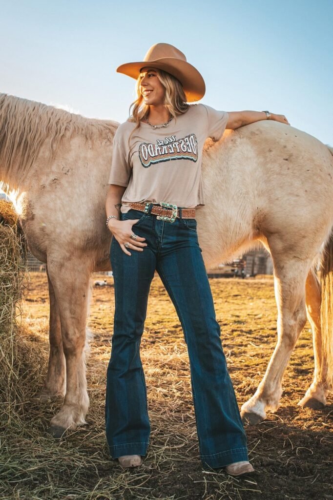 Beige Graphic T-Shirt + Dark Wash Flared Jeans + Tan Cowboy Hat + Turquoise Statement Belt
