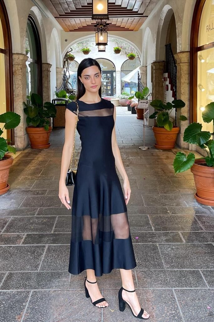 Black Cap-Sleeve Midi Dress with Sheer Panels + Black Ankle-Strap Heels + Gold Chain Handbag