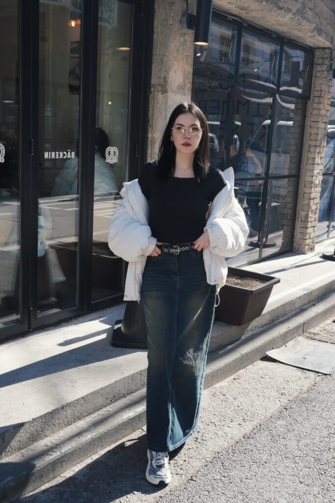 Black Fitted Top + White Puffer Jacket + Dark Wash Denim Maxi Skirt + Grey and White Athletic Sneakers