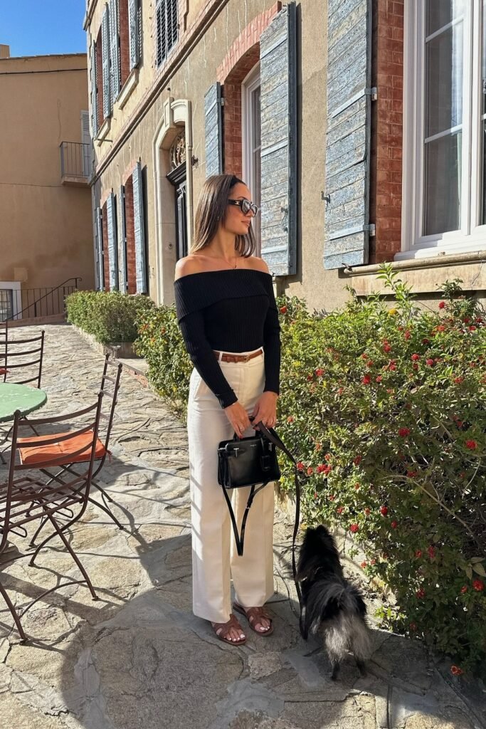 Black Off-the-Shoulder Ribbed Top + White High-Waisted Trousers + Brown Leather Slides