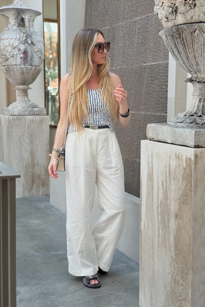 Blue and White Striped Smocked Top + White Wide-Leg Linen Trousers + Black Slide Sandals