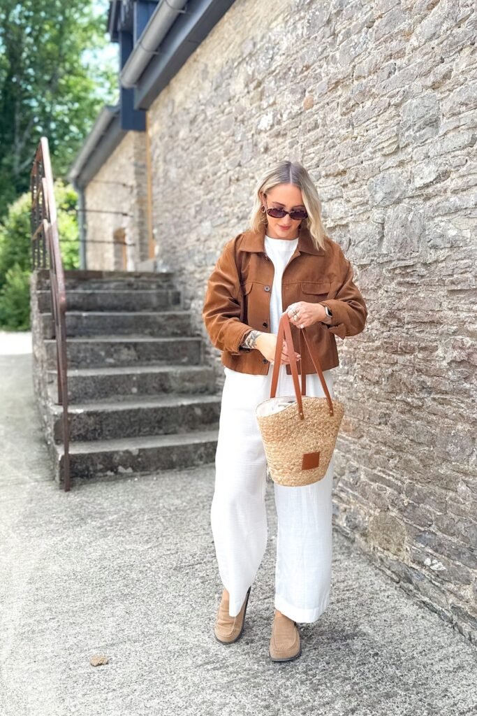 Brown Cropped Utility Jacket + White Wide-Leg Jumpsuit + Tan Suede Loafers