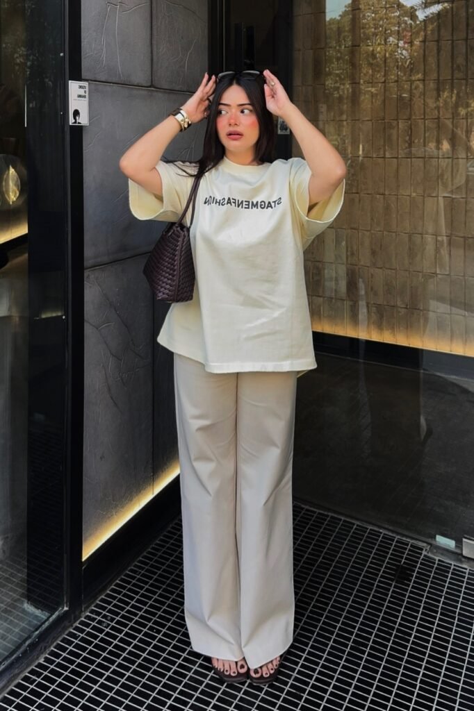 Cream Graphic T-shirt + Off-White Wide-Leg Trousers + Dark Brown Woven Bag