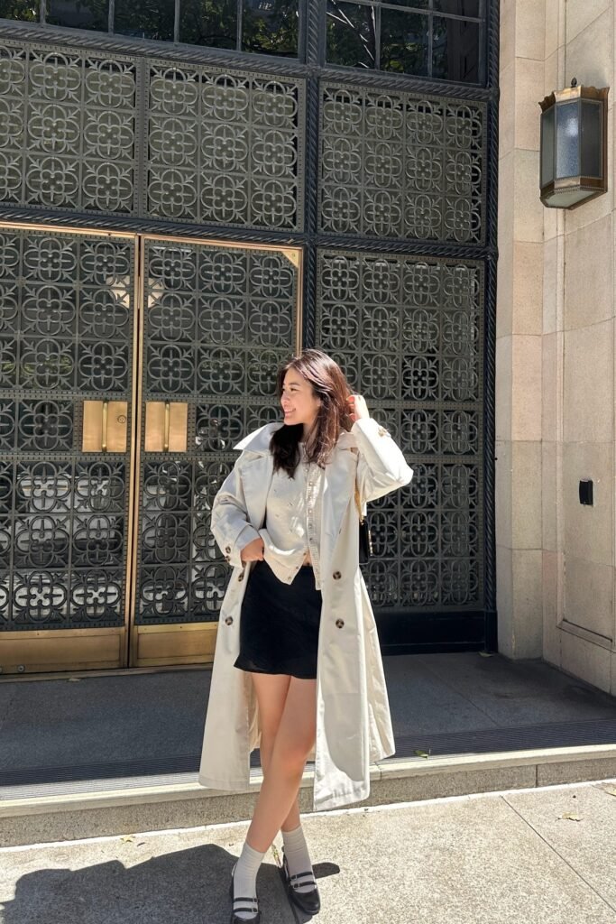 Cream Trench Coat + Cream Button-Up Cardigan + Black Mini Skirt + Black Mary Janes with White Socks