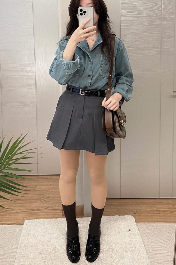 Denim Button-Down Shirt + Charcoal Pleated Mini Skirt + Black Loafers with Brown Socks