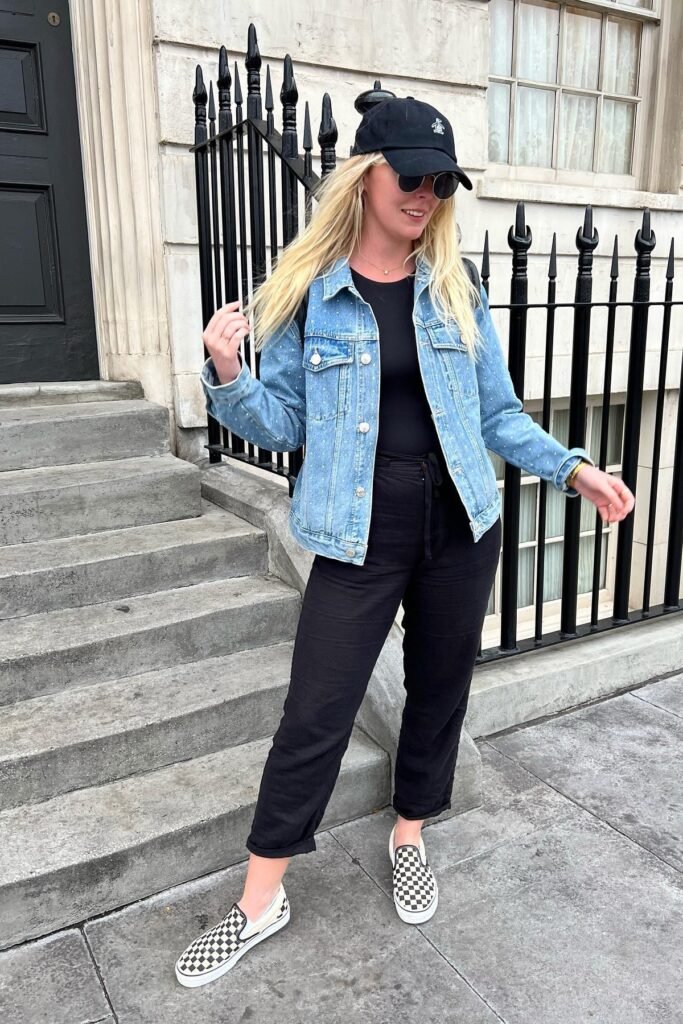 Embellished Denim Jacket + Black Bodysuit + Black Cropped Trousers + Checkered Slip-on Shoes + Black Baseball Cap