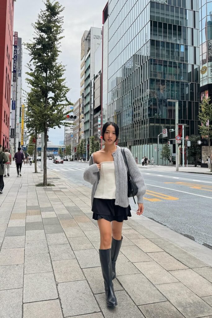 Grey Oversized Cardigan + White Strapless Tube Top + Black Ruffled Mini Skirt + Black Knee-High Boots