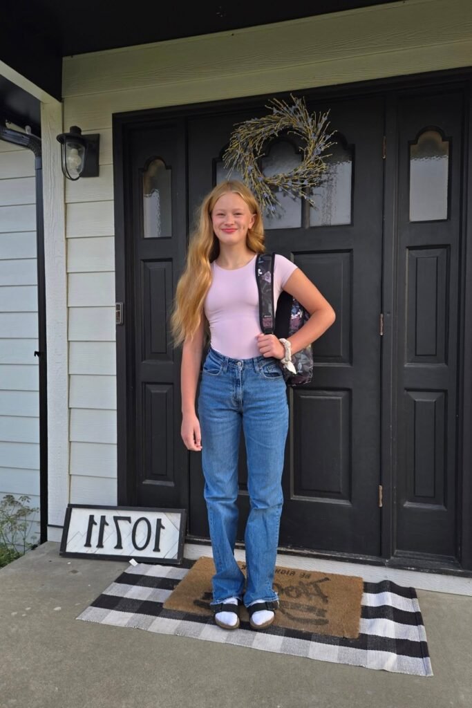 Light Pink Short-Sleeve Bodysuit + Medium Wash Straight-Leg Jeans + White Socks and Black Sandals
