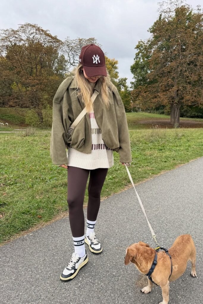Olive Bomber Jacket + Cream Patterned Oversized Sweater + Brown Leggings + White Socks + Black and White Sneakers