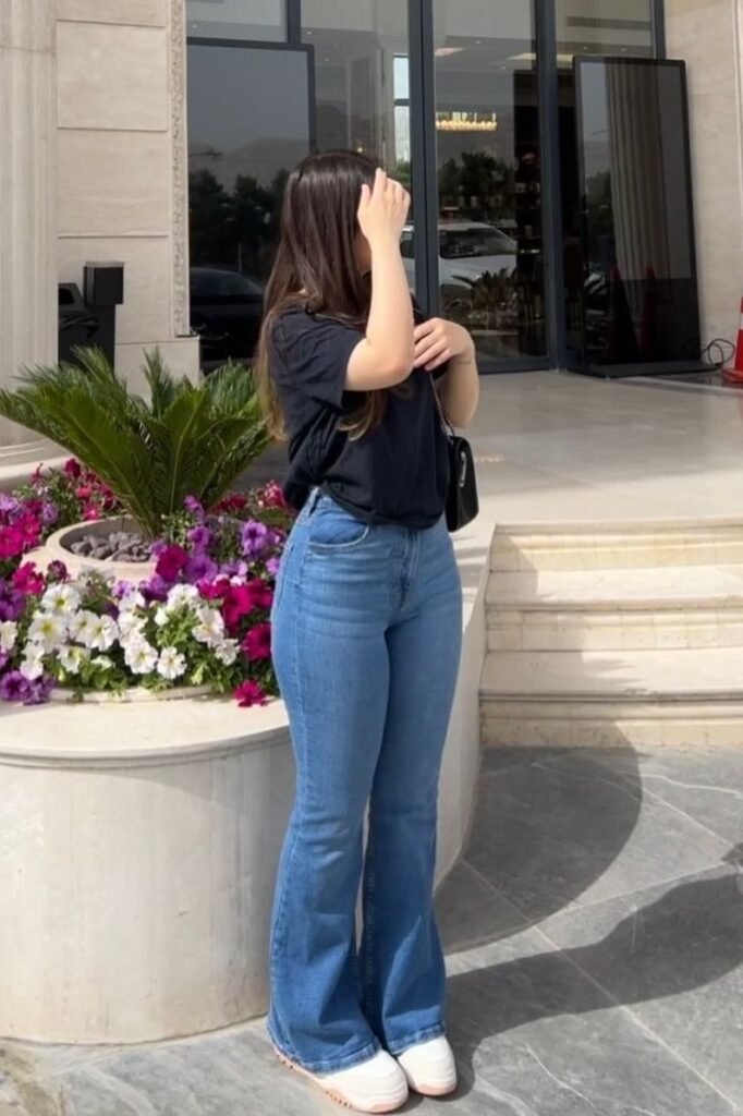 Oversized Black T-Shirt + Light Wash Flared Jeans + White Platform Sneakers