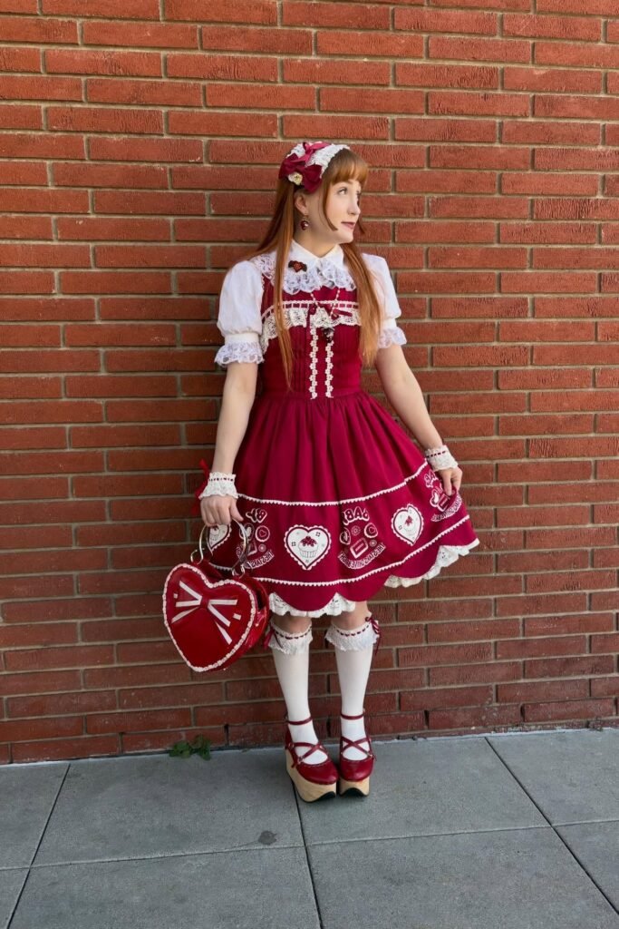 Red Heart-Print Jumper Dress + White Lace Blouse + Red Heart-Shaped Bag + Tan Platform Heels