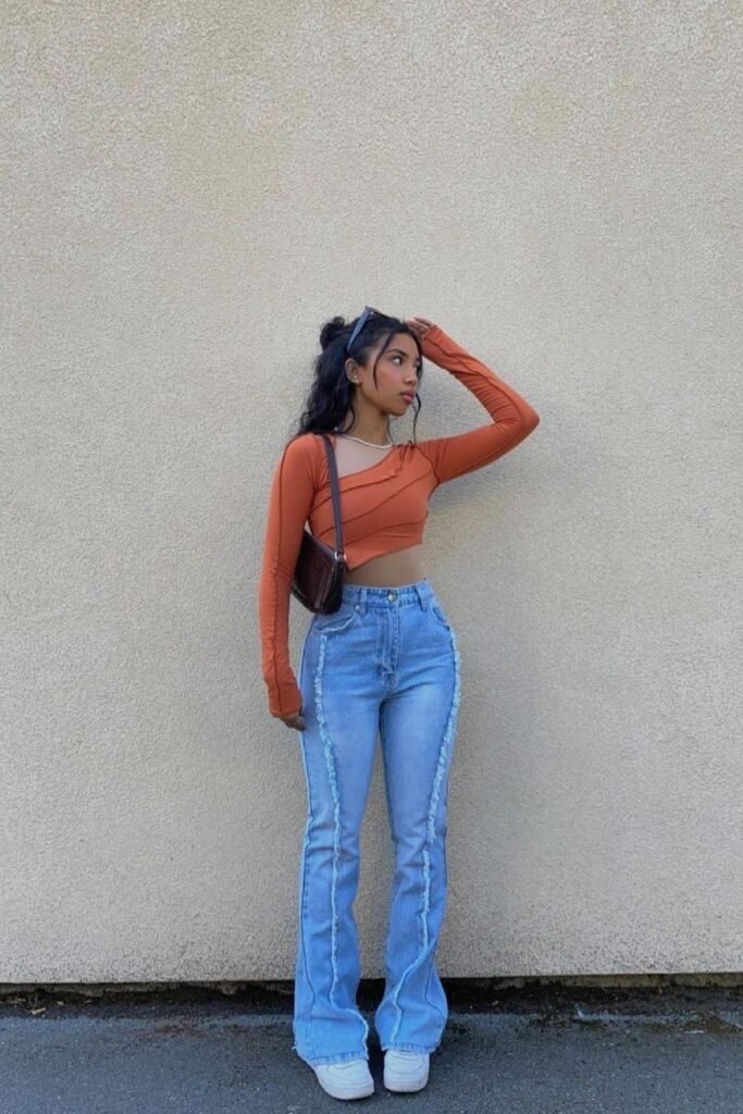 Rust Orange Asymmetrical Long Sleeve Crop Top + Blue Jeans with Raw-Edge Seam Detail + White Sneakers