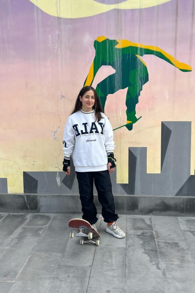 White Collegiate Sweatshirt + Black Straight-Leg Trousers + White & Grey Sneakers