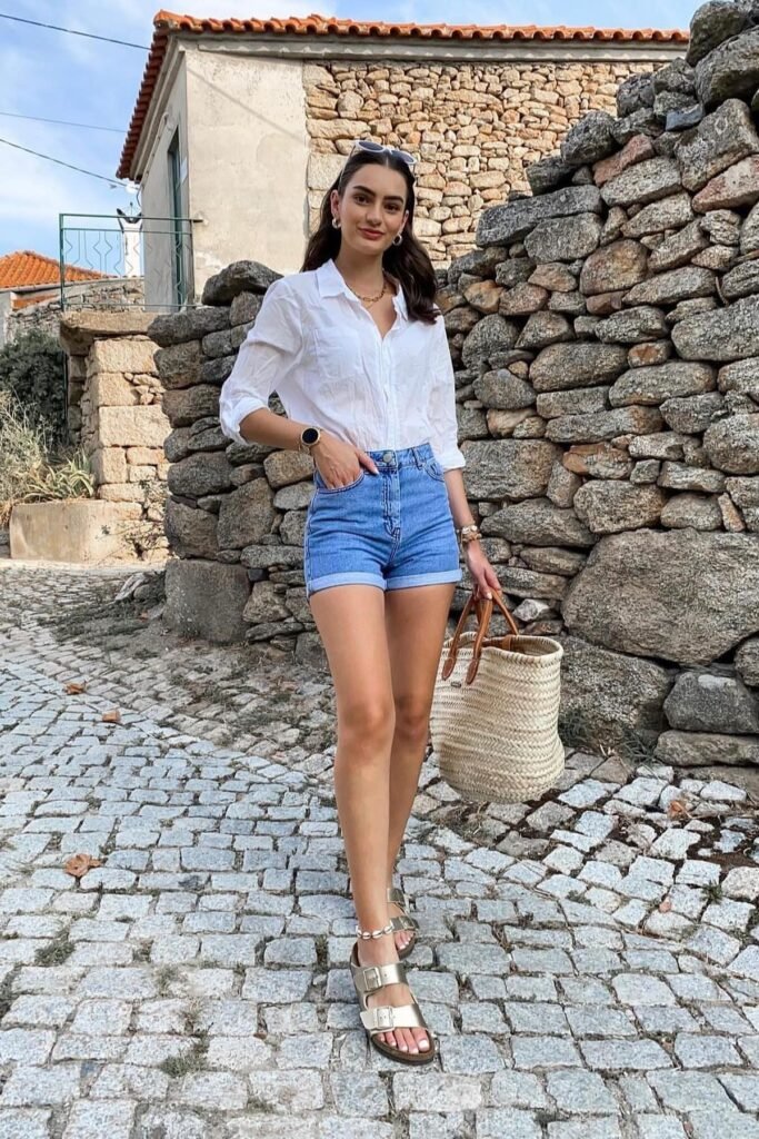 White Button-Down Shirt + High-Waisted Denim Shorts + Gold Double-Strap Sandals
