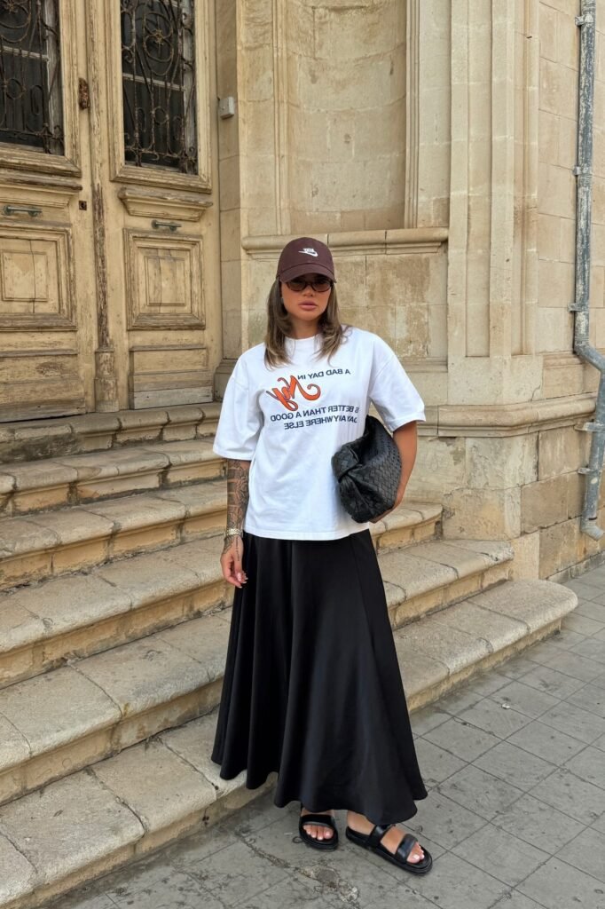 White Graphic T-Shirt + Black A-Line Maxi Skirt + Black Double-Strap Slides
