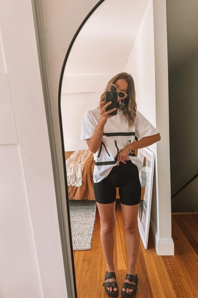 White Graphic T-shirt + Black Biker Shorts + Black Double-Strap Sandals