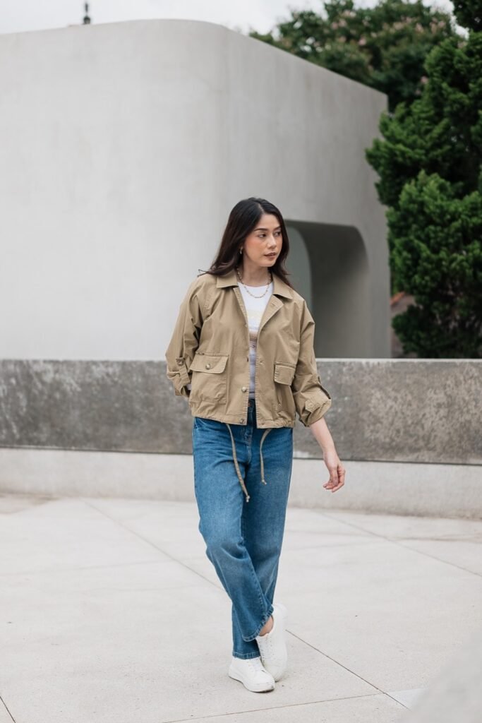  White Graphic Tee + Tan Utility Jacket + Medium Wash Straight Jeans + White Sneakers