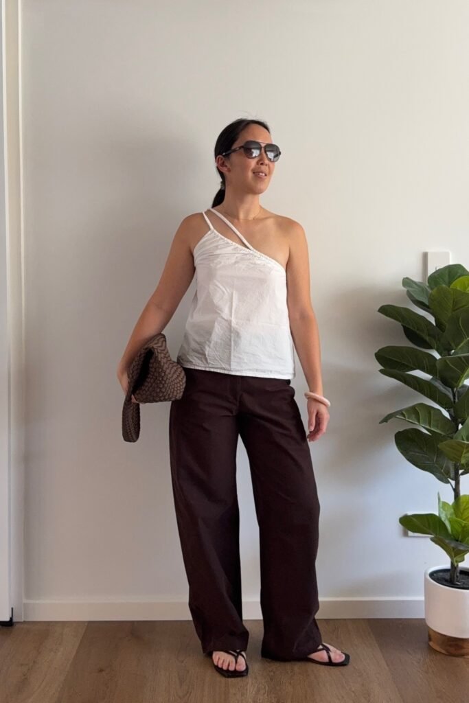 White One-Shoulder Asymmetrical Tank Top + Dark Brown Wide-Leg Trousers + Black Thong Sandals