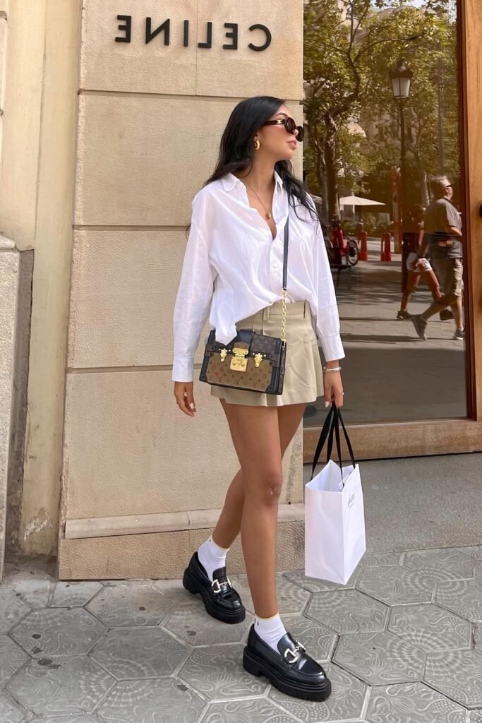 White Oversized Button-Down Shirt + Beige Pleated Mini Skirt + White Socks + Black Platform Loafers