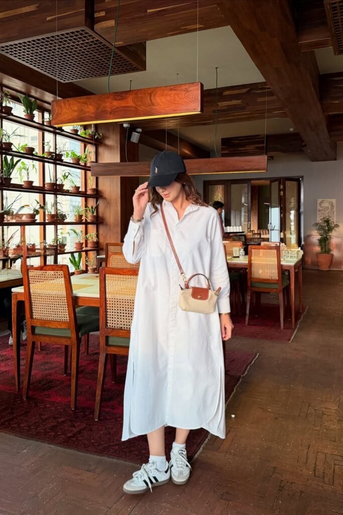 White Oversized Shirt Dress + White Sneakers with Black Stripes + Black Baseball Cap + Mini Crossbody Bag
