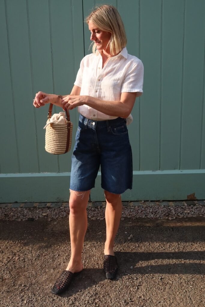 White Short-Sleeve Button-Down + Indigo Raw-Hem Jorts + Woven Straw Bucket Bag + Black Woven Mules