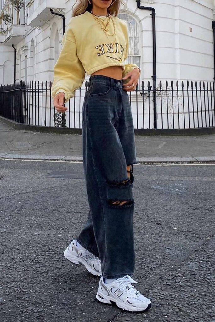 Yellow Cropped Sweatshirt + Distressed Dark Grey Wide-Leg Jeans + White New Balance Sneakers