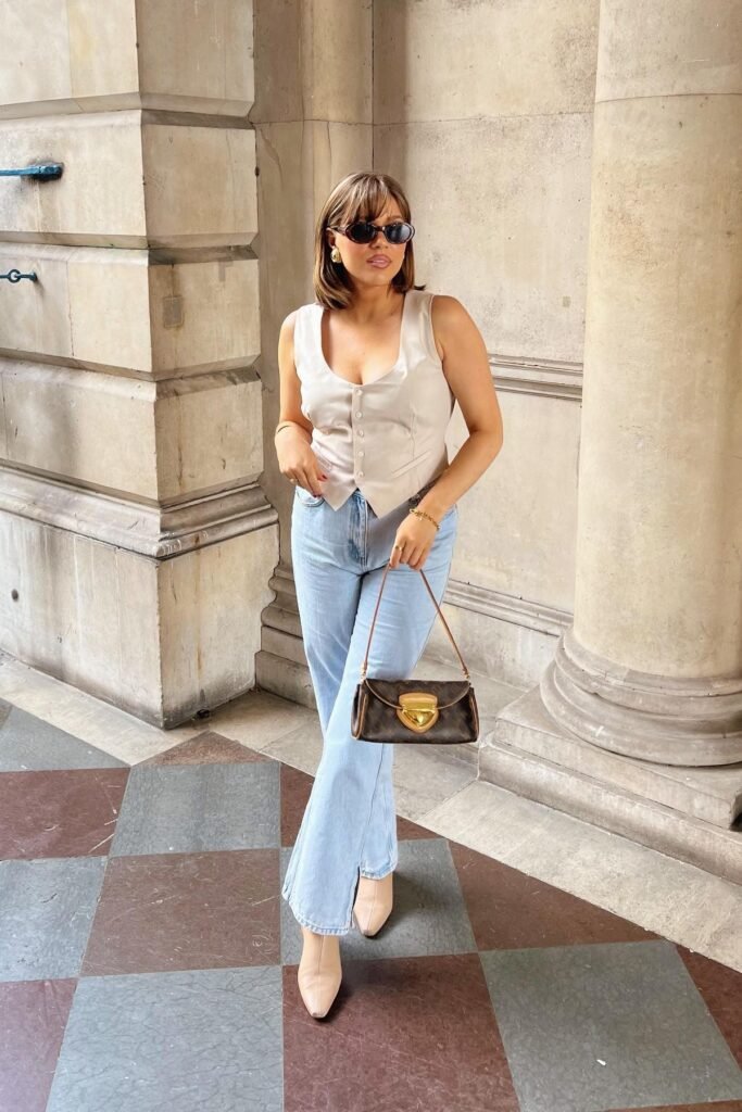 Beige Button-Up Vest + Light Wash Flare Jeans + Beige Square-Toe Boots + Brown Monogram Shoulder Bag