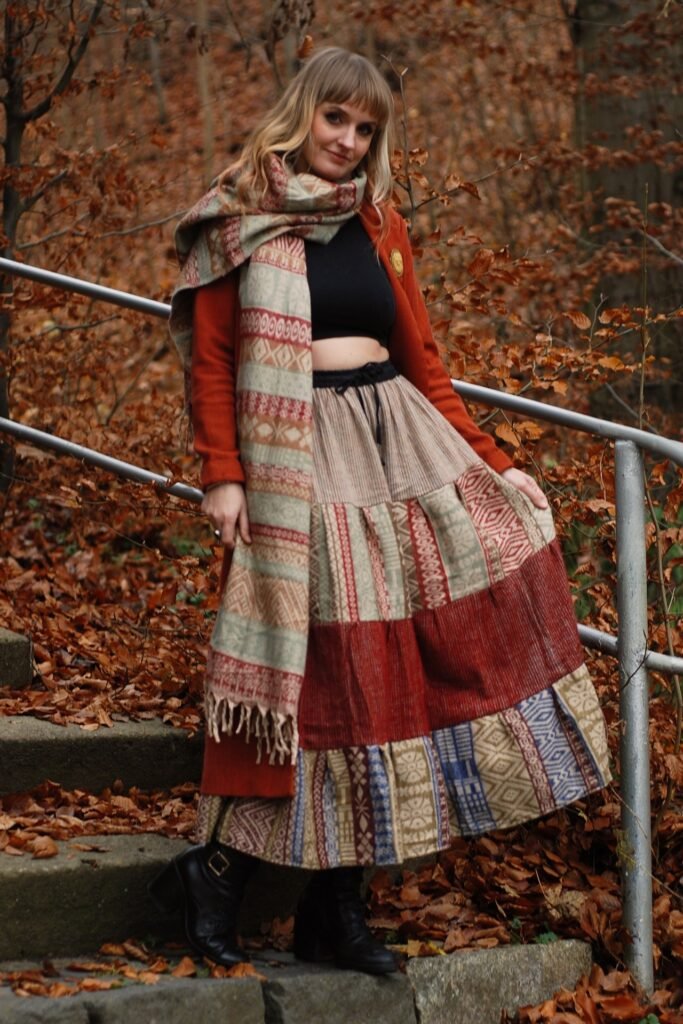 Black Crop Top + Red and Tan Patterned Patchwork Skirt + Orange Cardigan + Multi-Patterned Scarf + Black Heeled Boots
