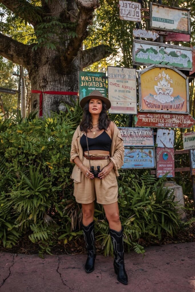 Black Crop Top + Tan Button-Up Shirt + Tan High-Waisted Shorts + Brown Fedora + Black Cowboy Boots