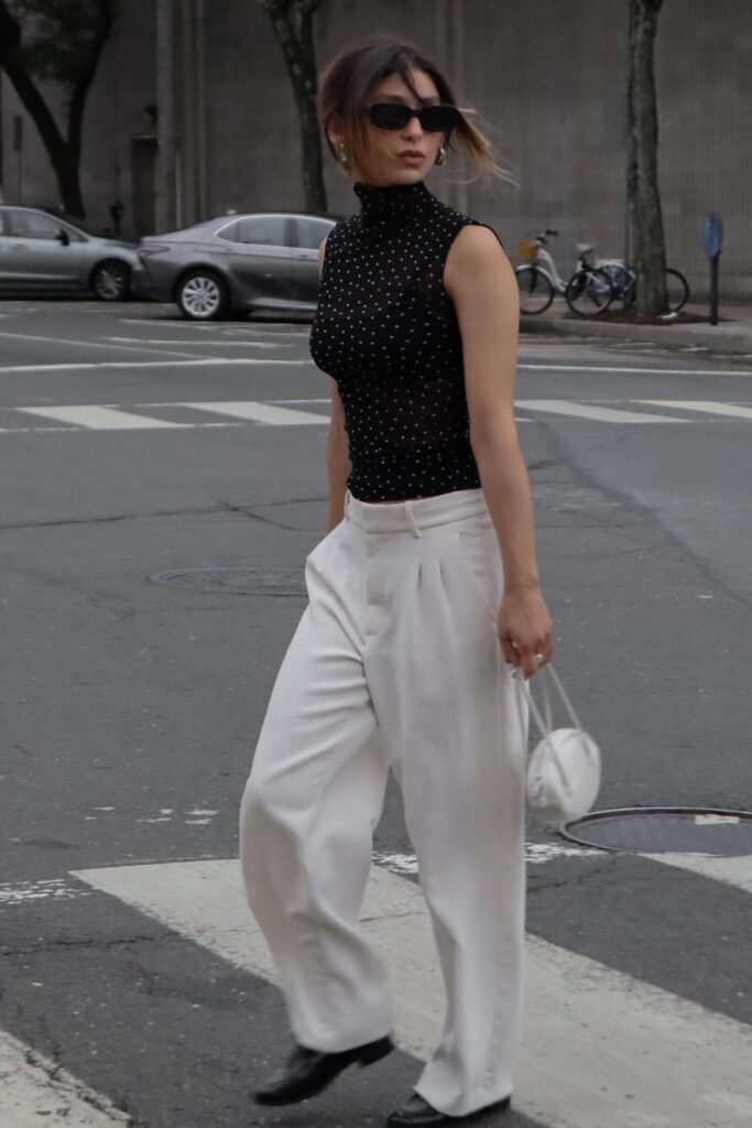 Black Dotted Sleeveless Turtleneck + White Pleated Trousers + White Mini Round Bag + Black Loafers
