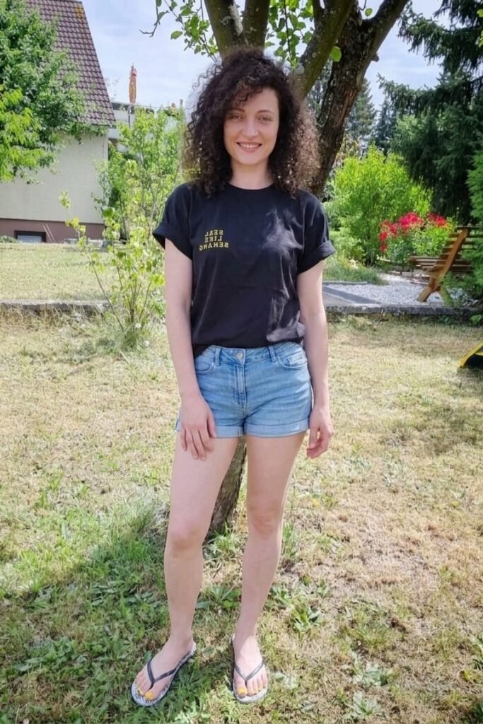 Black Graphic T-Shirt + Light Wash Denim Shorts + Patterned Flip Flops