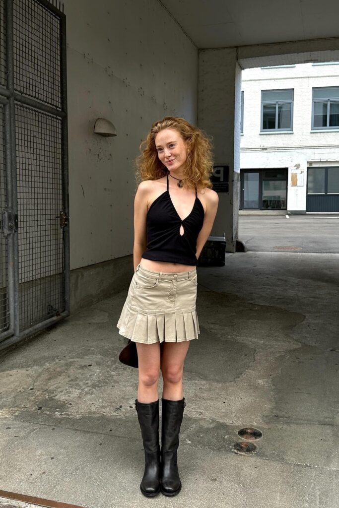 Black Halter Neck Cut-Out Top + Khaki Pleated Mini Skirt + Black Knee-High Leather Boots