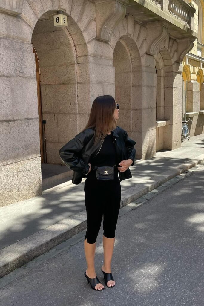 Black Leather Bomber Jacket + Black Top + Black Capri Leggings + Black Open-Toe Heeled Mules