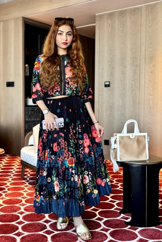Black Long-Sleeve Crop Top with Colorful Floral Print + Matching Pleated High-Waisted Maxi Skirt + Gold Open-Toe Slides