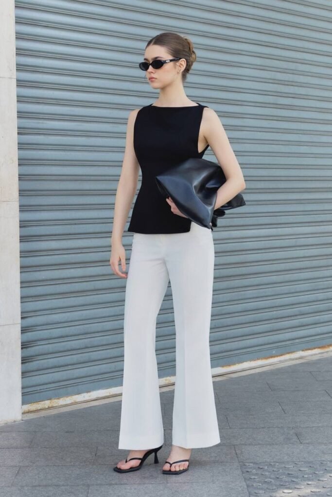 Black Sleeveless Boat Neck Top + White High-Waisted Flare Trousers + Black Strappy Heeled Sandals