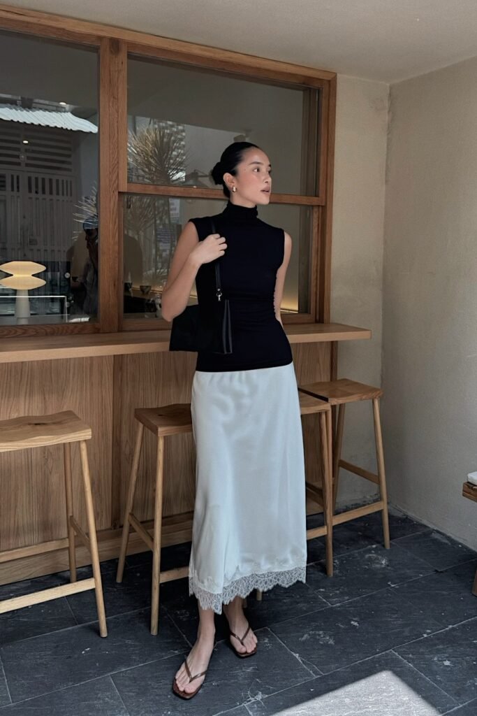 Black Sleeveless Turtleneck + White Lace-Trim Midi Skirt + Black Shoulder Bag + Brown Flip-Flop Sandals