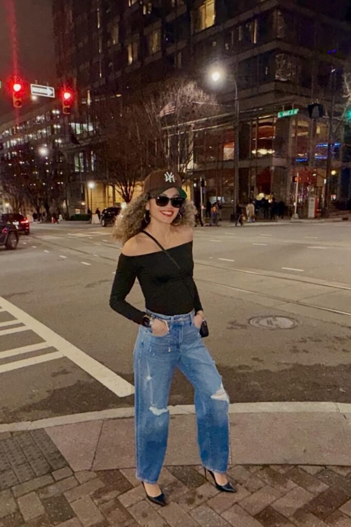 Brown Baseball Cap + Black Off-the-Shoulder Long Sleeve Top + Distressed Wide-Leg Jeans + Black Pointed-Toe Pumps