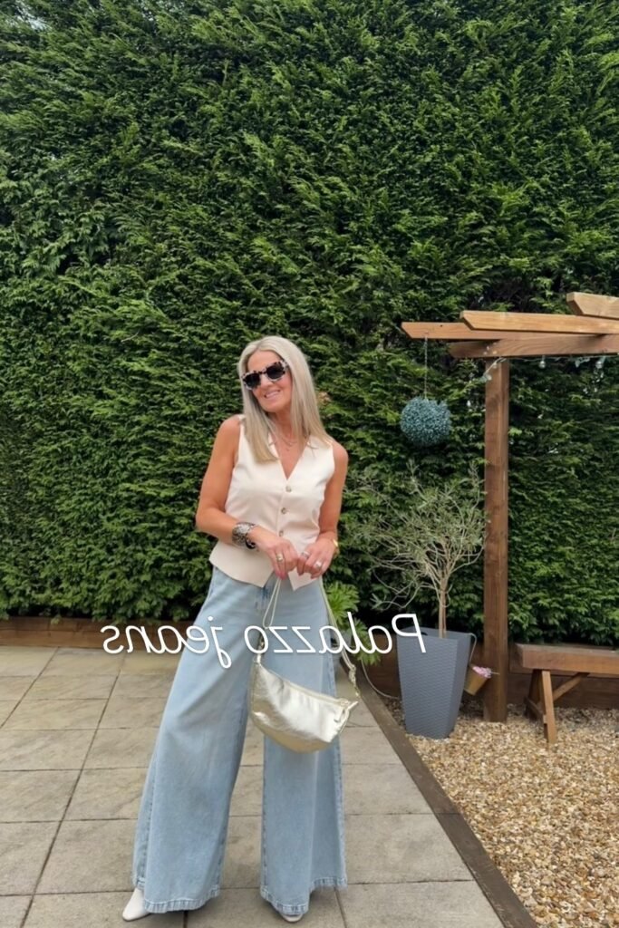 Cream Tailored Vest + Light Wash Palazzo Jeans + White Pointed-Toe Boots + Gold Metallic Bag