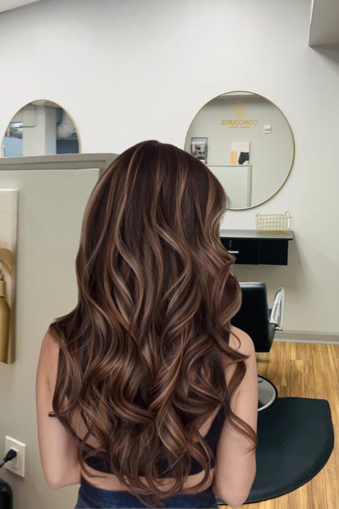 Defined Brunette Curls with High-Contrast Sandy Blonde Highlights