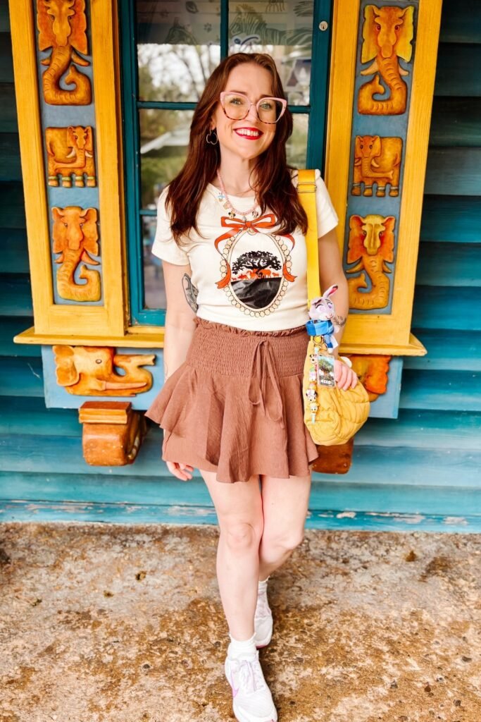 Graphic Cream T-Shirt + Brown Ruffled Skirt + White Athletic Sneakers