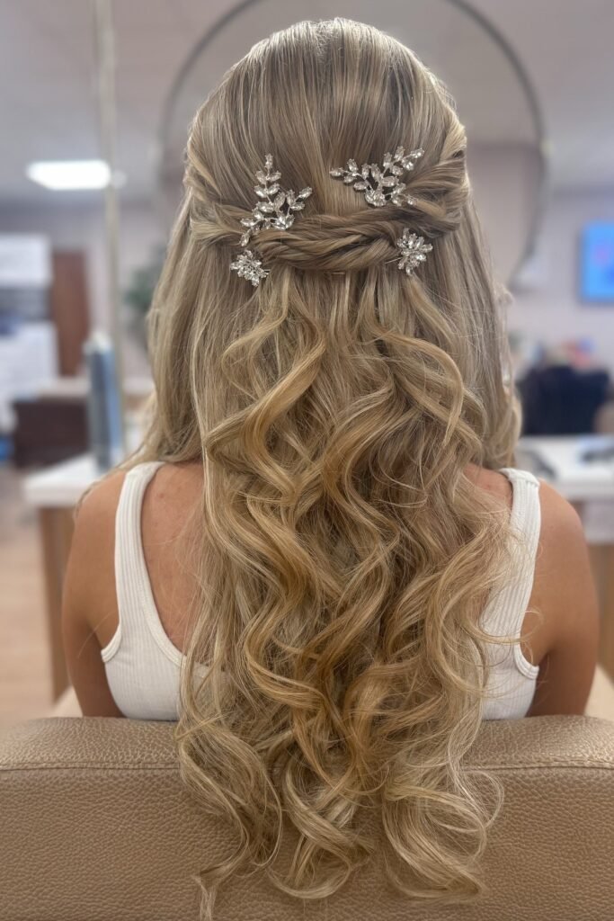 Half-Up Twisted Crown with Voluminous Curls and Floral Jewels