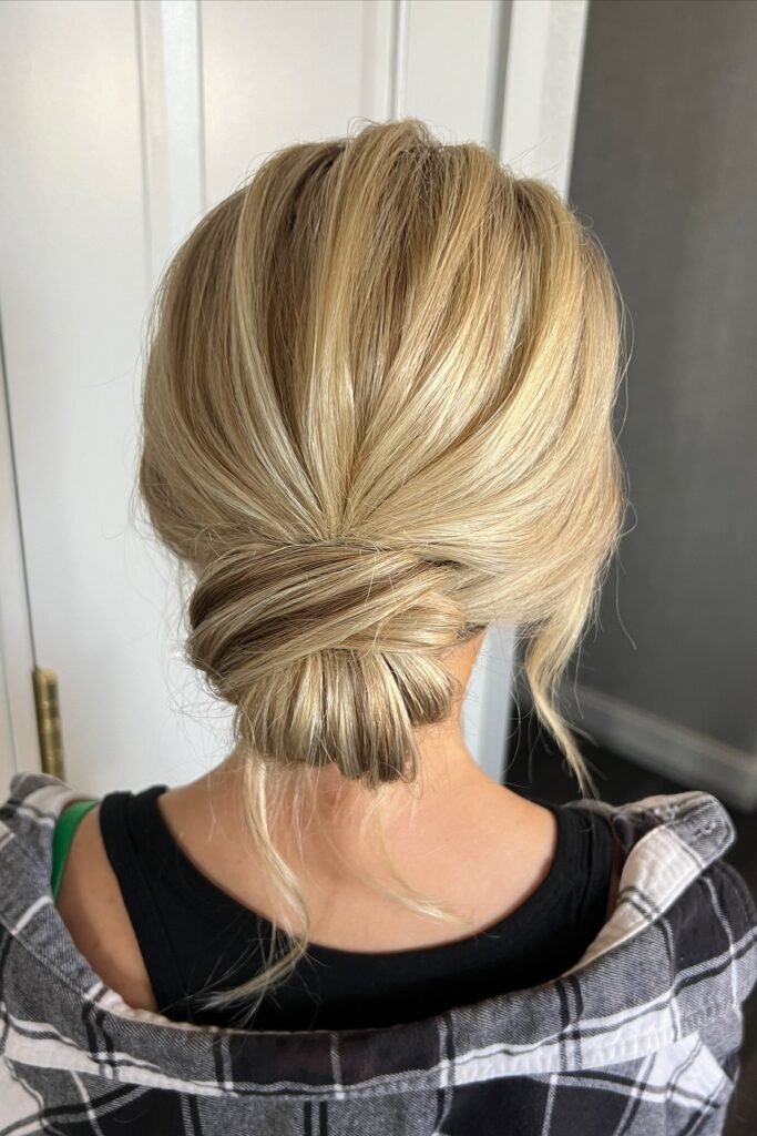 Low Tucked Chignon with Smooth Voluminous Crown and Blonde Balayage
