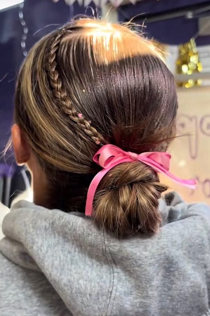 Sleek Low Braided Bun with Side Braid and Pink Bow