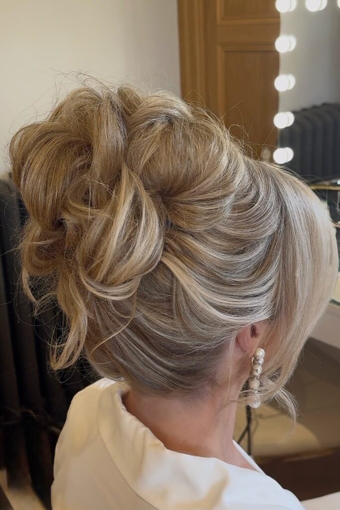 Textured High Updo with Dimensional Blonde Sweeps