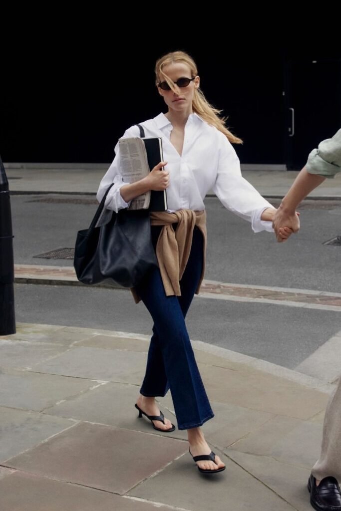 White Button-Down Shirt + Camel Sweater (Tied) + Dark Wash Flared Jeans + Black Kitten-Heel Sandals