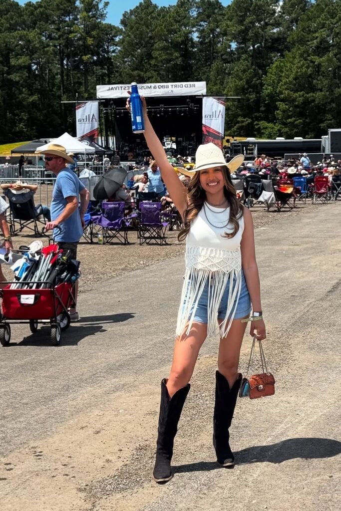 White Macramé Fringe Crop Top + High-Waisted Denim Shorts + Black Knee-High Cowboy Boots