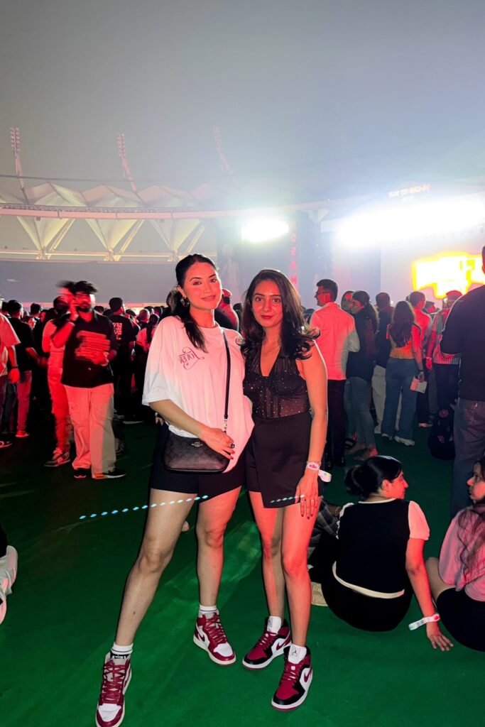 White Oversized Graphic T-Shirt & Black Sparkly Mesh Top + Black Mini Shorts & Black Skort + Red and White High-Top Sneakers