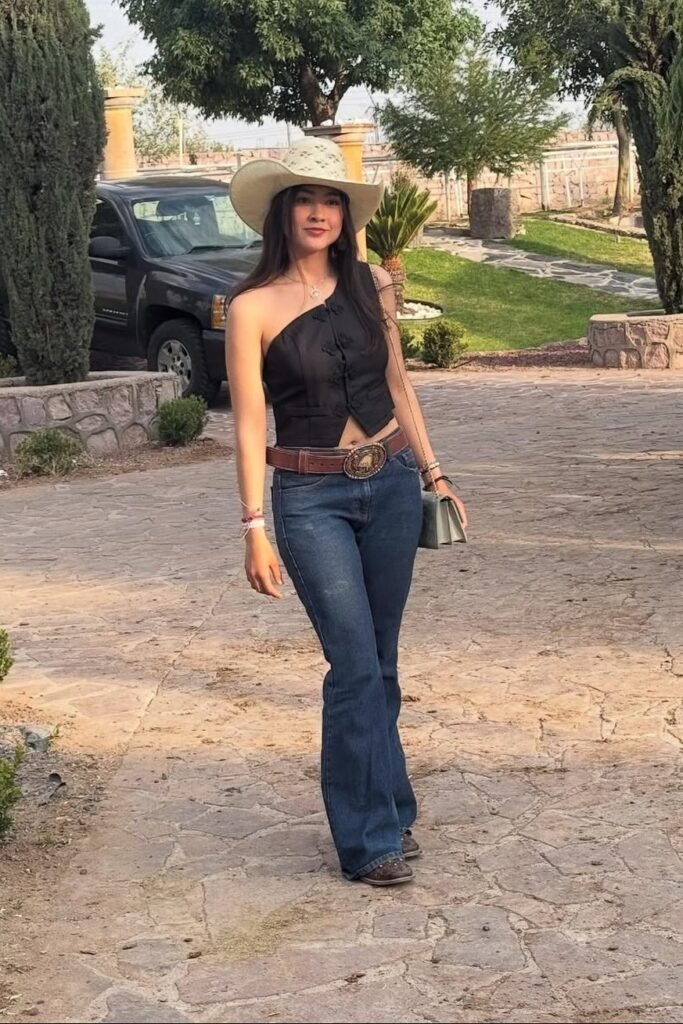White Straw Cowboy Hat + Black One-Shoulder Vest + Blue Flared Jeans