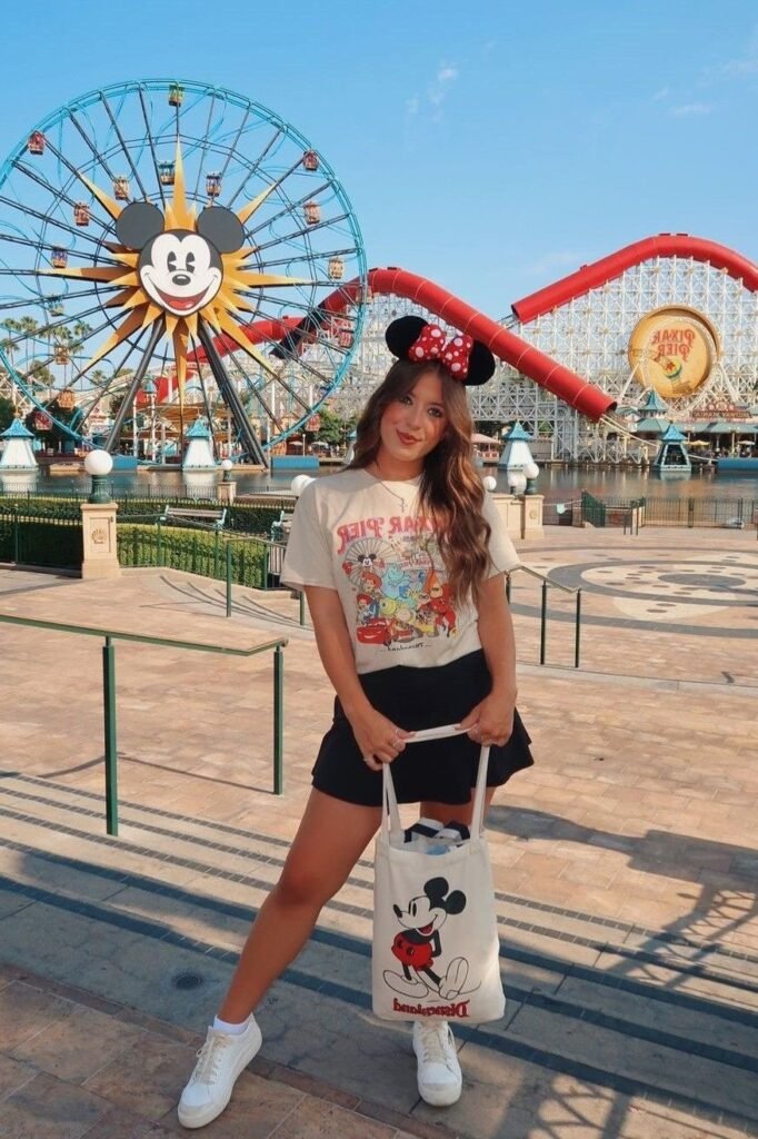 Beige Pixar Pier Graphic Tee + Black Skater Skirt + White Classic Sneakers
